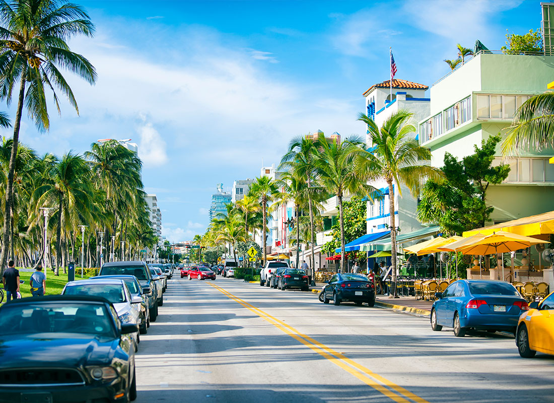 Contact - Early Morning View Down Ocean Drive Lined With Palm Trees and Art Deco Hotels in South Beach Florida